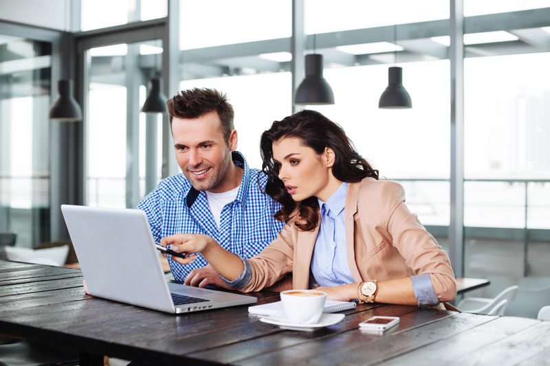 man and woman working on laptop